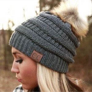 C.C.gray cable-knit beanie hat with a faux fur pom-pom.